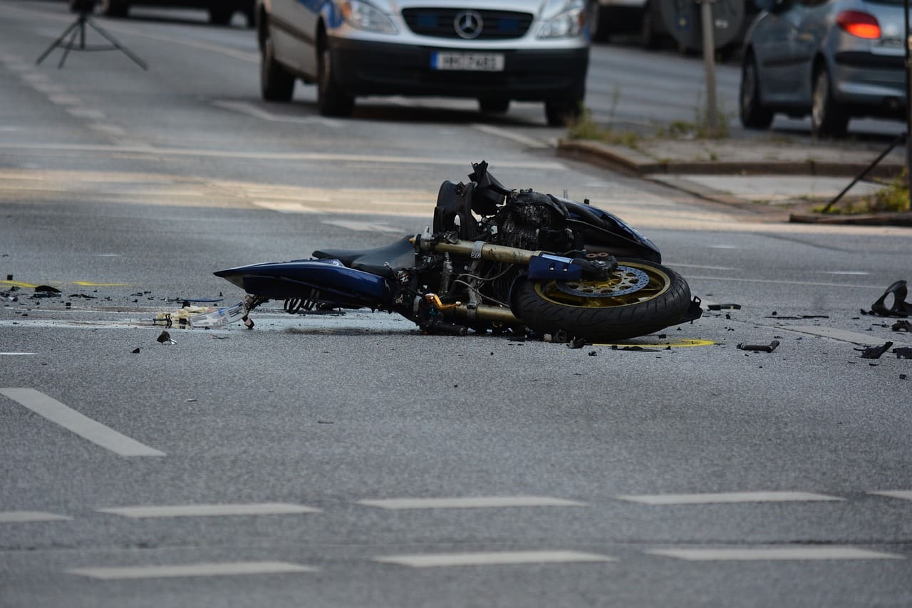 A motorcycle that has been hit by the side of the road.
