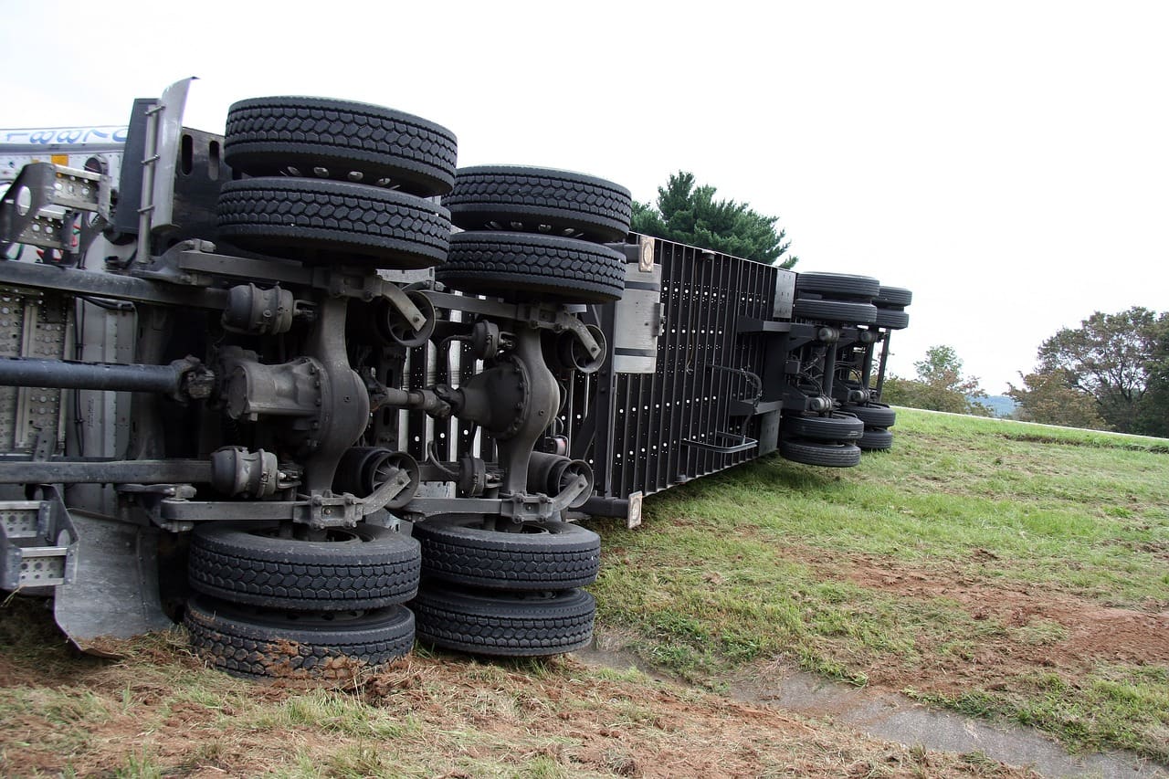 A truck that has been overturned by the side of it.