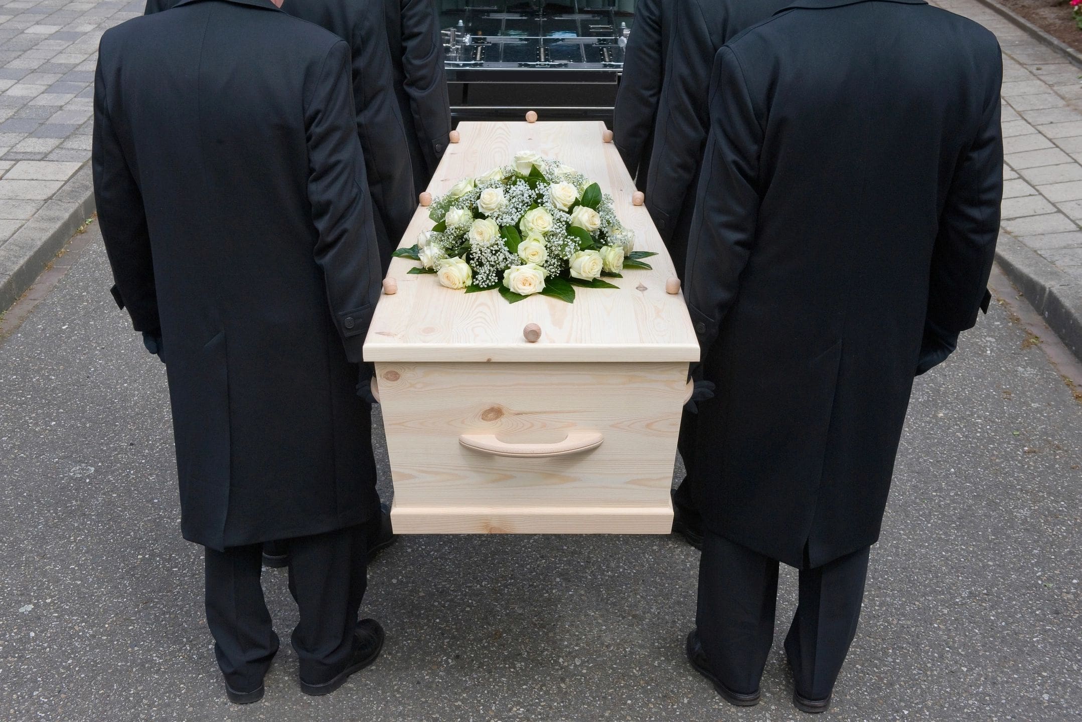 fm=f_6559 A group of people standing around a wooden casket.